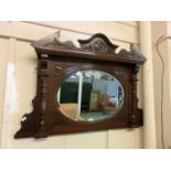 Edwardian carved walnut over mantle mirror with oval bevelled glass
