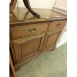 A reproduction wooden cabinet having two drawers above cupboard doors