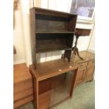 A mid-20th century teak sliding glazed door cabinet with a distressed wooden bookcase