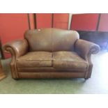 A tan leather two seat sofa