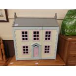 A hand crafted painted doll's house with selection of furniture and associated items