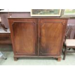 An 18th century mahogany linen press, two panelled cupboard doors enclosing five slides on later