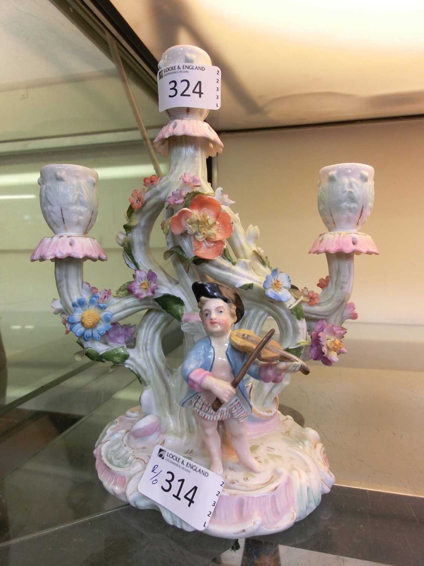 Decorative continental ceramic candelabra with model of boy playing violin to base