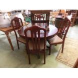 A modern cherry wood effect pedestal dining table with a set of four matching chairs