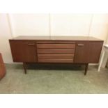 A mid-20th century teak sideboard, four central drawers flanked by cupboard doors