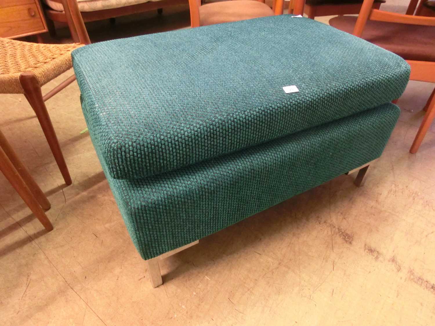 A blue fabric upholstered pouffe