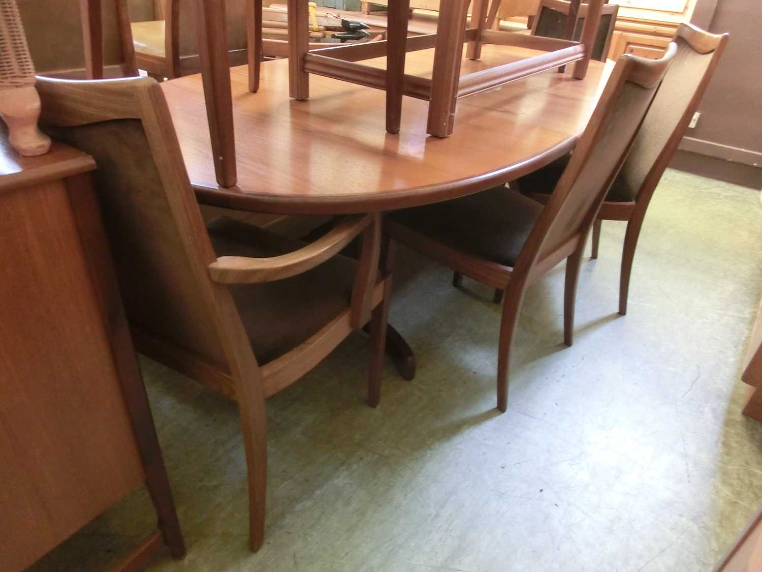 A mid-20th century teak oval extending dining table with a set of six (four plus two) matching