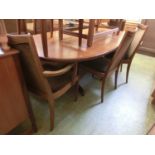 A mid-20th century teak oval extending dining table with a set of six (four plus two) matching
