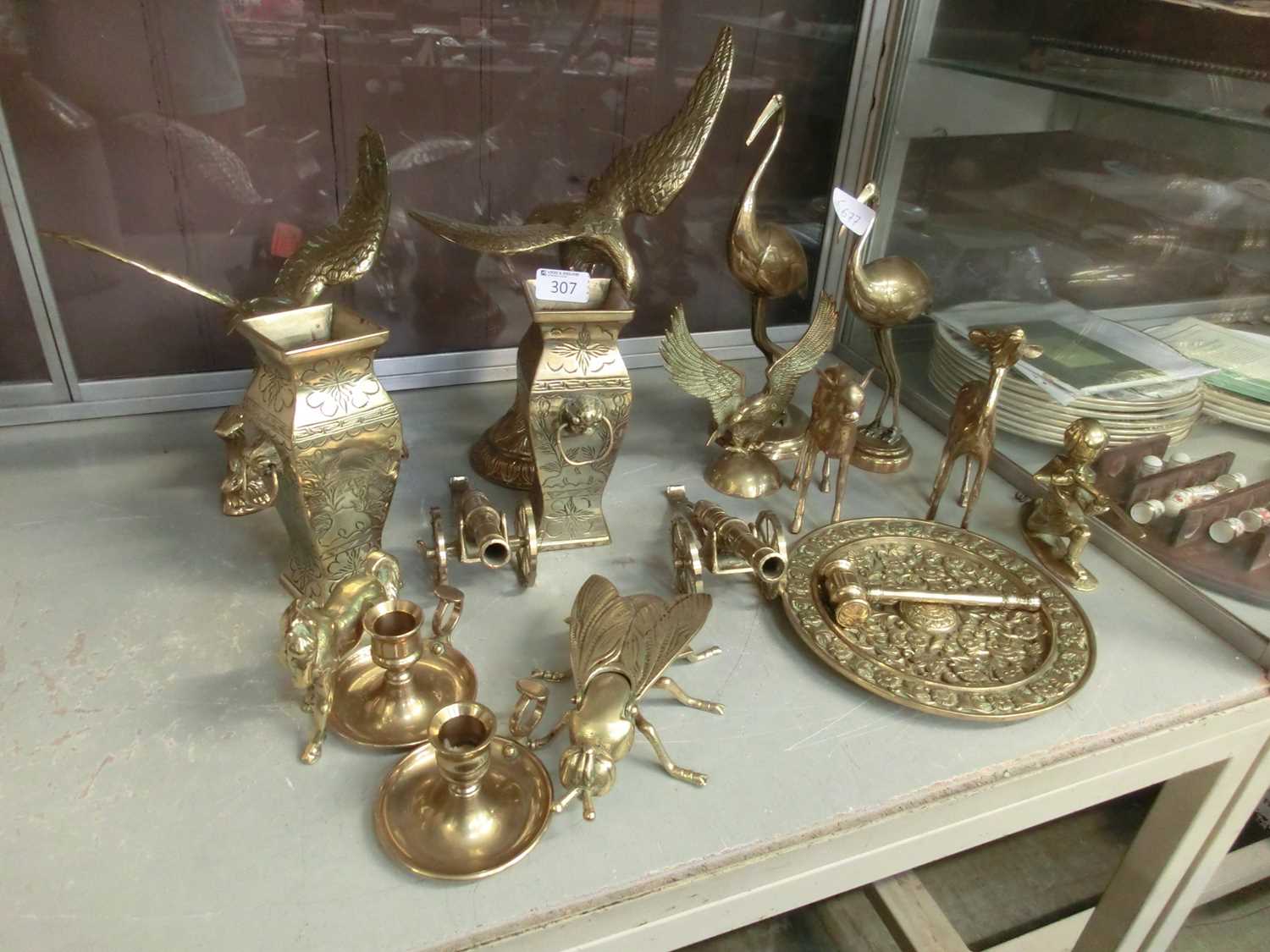 A collection of brass models to include vases, eagles, cannons, etc