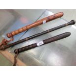 Two turned wooden truncheons together with an eastern leather covered club