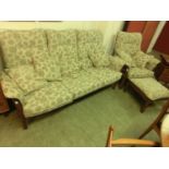 An Ercol three seat sofa together with matching armchair and footstool