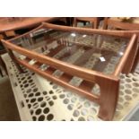 A walnut and glass topped rectangular coffee table with magazine rack below