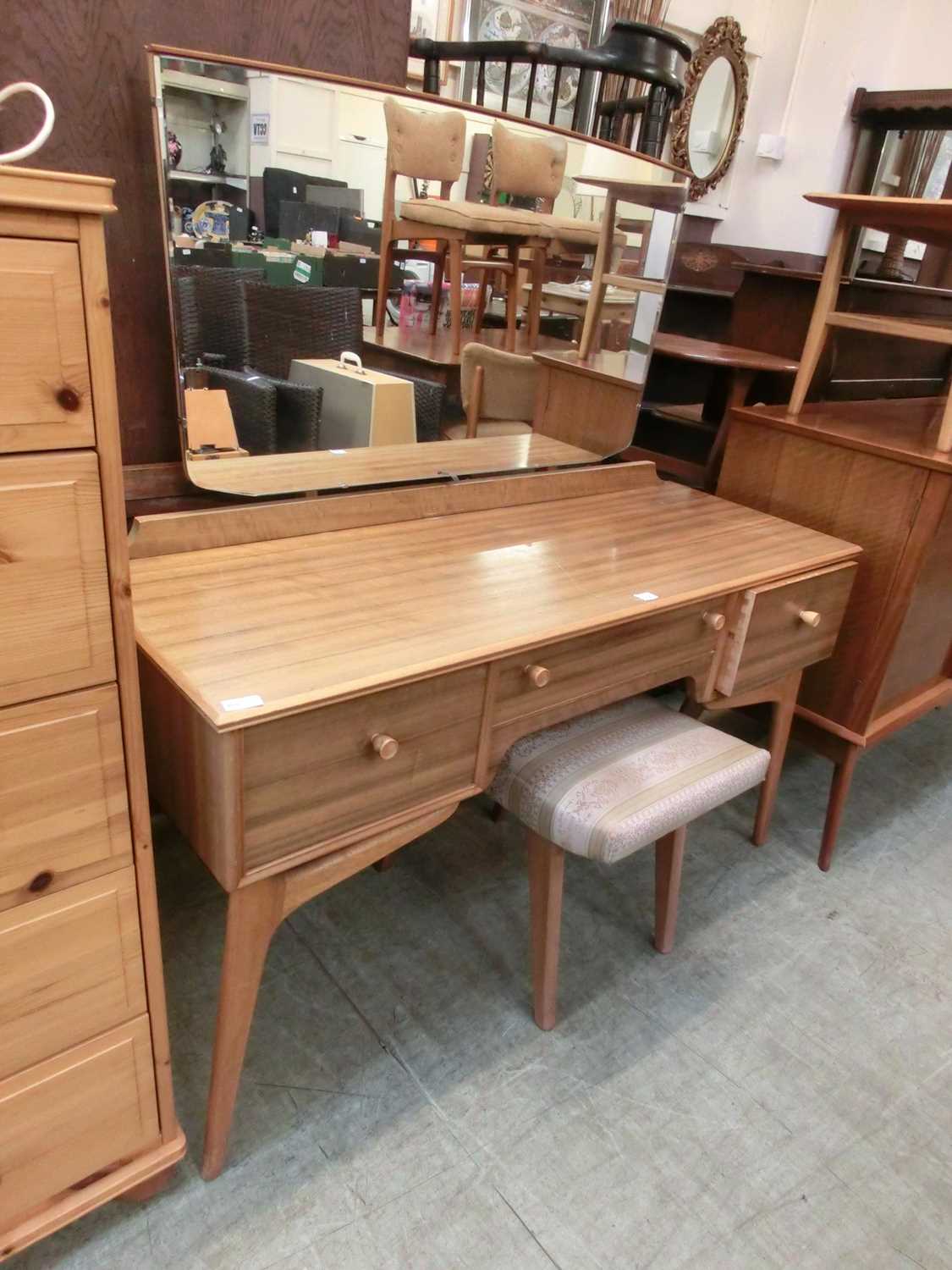 A modern walnut finish mirrored back dressing table with three drawers and matching stool