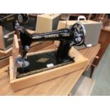 A Singer hand operated sewing machine with case