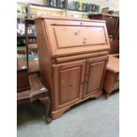 A Ducal pine bureau, the fall front over shallow drawer and two cupboard doors