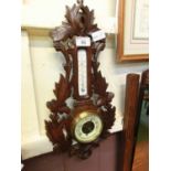 A Black Forest style aneroid barometer and thermometer