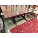 An early 20th century oak draw-leaf dining table