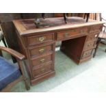 A late Victorian walnut pedestal desk of seven drawers with tooled leather top