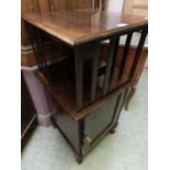 A mahogany revolving open bookcase over cupboard