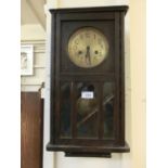 An early 20th century oak cased drop dial wall clock