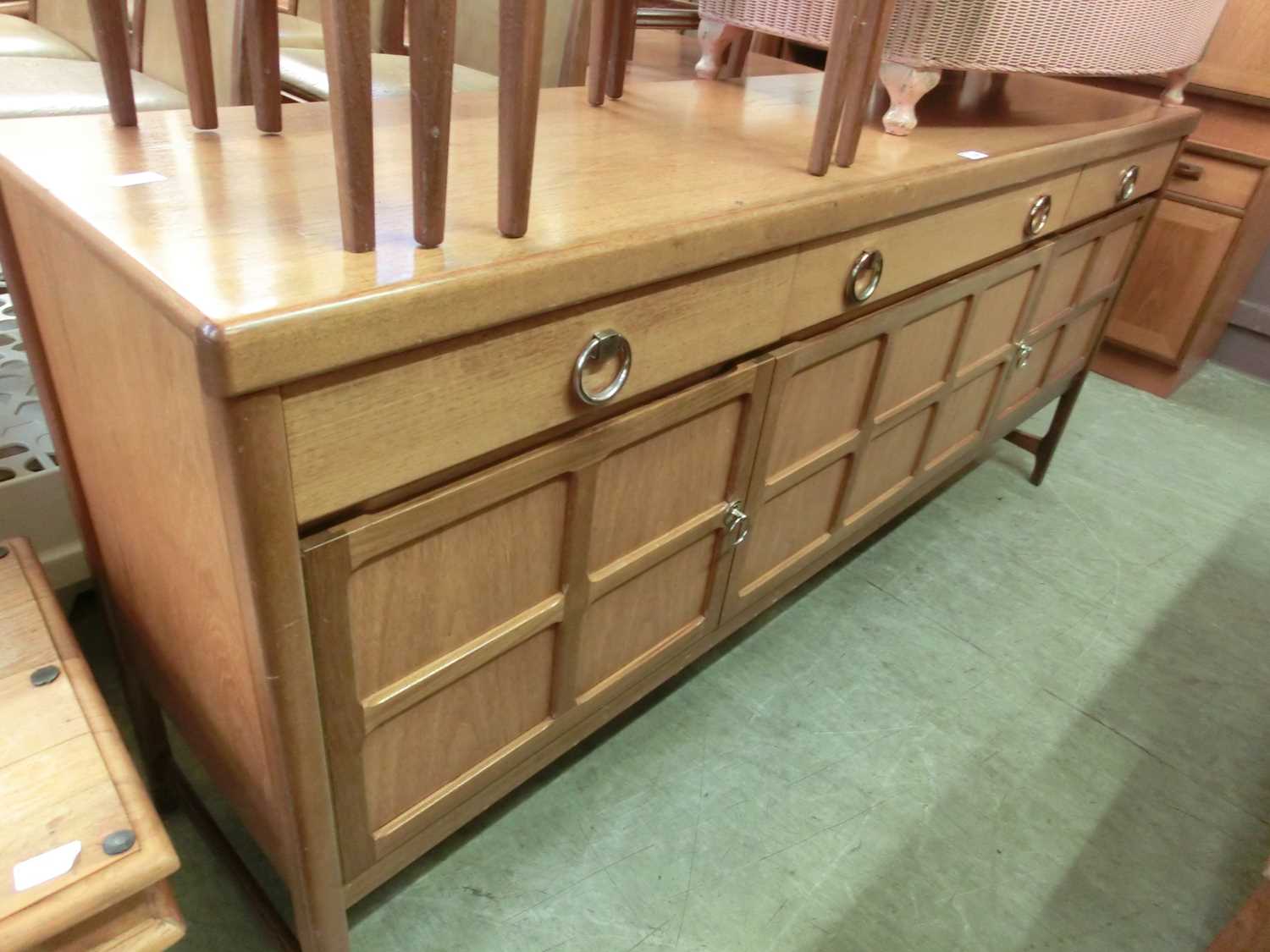 A mid-20th century teak sideboard with three cupboards and three drawersMinor knocks and scratches