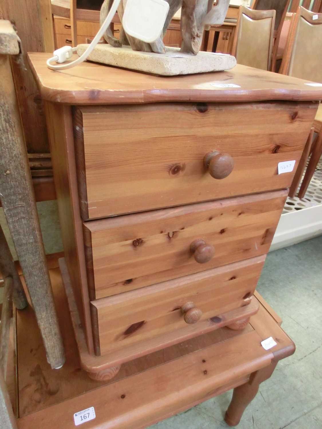 A modern pine bedside chest of three drawers