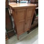 An Edwardian inlaid walnut music cabinet on square tapered supports and spayed feet