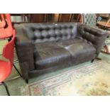 A dark brown leather upholstered two seat settee