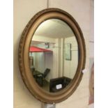 A gilt framed oval mirror