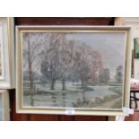 A framed oil on board of trees by river signed N.E.Ellis