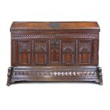 An early 18th century continental oak coffer/ark, the trapezoid top revealing a vacant interior over