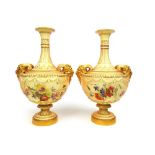 A pair of Royal Worcester blush ivory vases, the satyr masks over the floral painted bodies, date