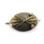 A yellow and white metal Zulu design brooch with crossed clubs/spears on a shield. Marked 'Hammon