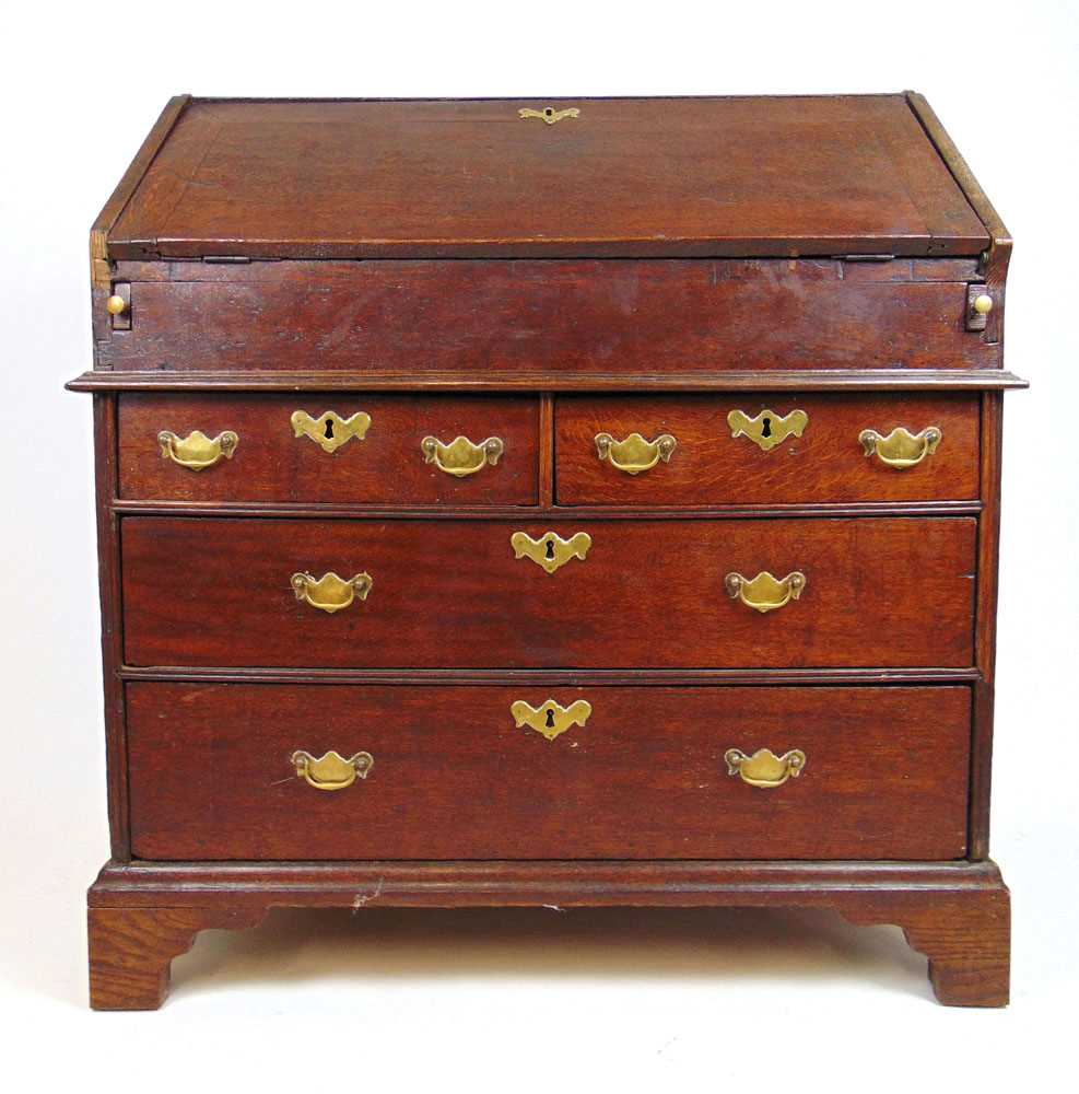 An early 18th century oak bureau, the fall front with fitted interior and well over two short and