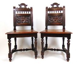 A pair of 19th century oak side chairs, the carved top rail with lion finials over a carved back