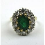 A yellow metal, emerald and diamond cluster ring marked '18ct', the ten round cut stones totaling