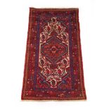 A handwoven Persian rug, the triple line border surrounding the cream ground field with central