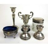 An assortment of silver items to include candle holders, dressing table pot, salt and a trophy.