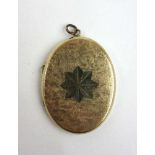 An early 20th century yellow metal locket with engraved decoration to front, l. 4 cm