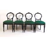 A set of four late Victorian ebonised and parcel gilt balloon back chairs, the carved back over