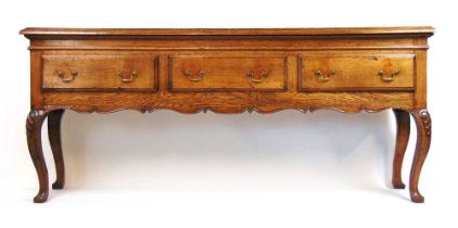 A 20th century 18th century style oak dresser base, the moulded top over three drawers and a