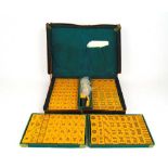 An early 20th century Bakelite mahjong set in leather case and four counter standsCase coming