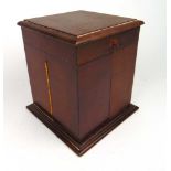 An early 20th century mahogany perfume box, the lid lifting to release the two door front containing