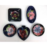 Three Moorcroft pin dishes together with two ashtrays