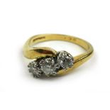 An 18ct gold and diamond ring, the three round cut stones in a crossover setting. Approx. weight 4.