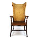 An early 20th century walnut 'porters' chair, the upholstered wing back over open arms with barley