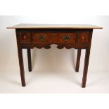 An 18th century and later oak side table, the later top over three drawers and a shaped apron on