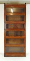 An early 20th century oak sectional bookcase by Lebus, comprising of cornice, plinth and six