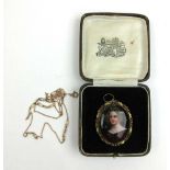 A 19th century yellow metal mounted portrait pendant depicting a young lady. The back with glazed