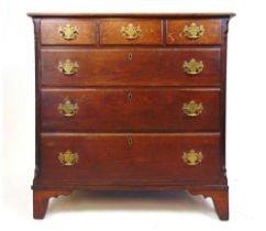 A mid 18th century oak chest of drawers, three short drawers over three graduated drawers flanked by